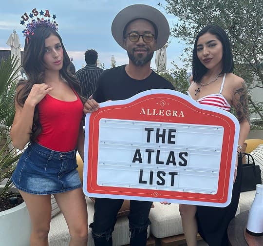 Guests holding The Atlas List sign