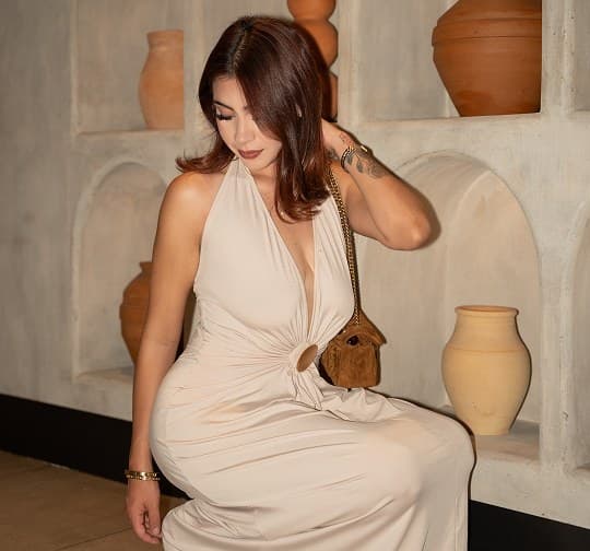 A guest in cream seated by the vases